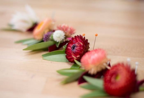 boutonnieres in a line on a table