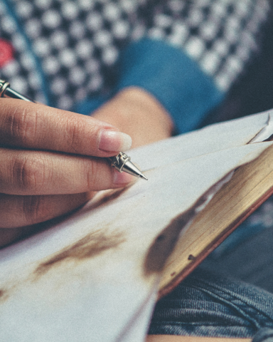 PERSON WRITING IN A BOOK