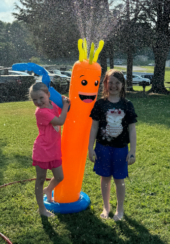 kids playing in the sprinkler